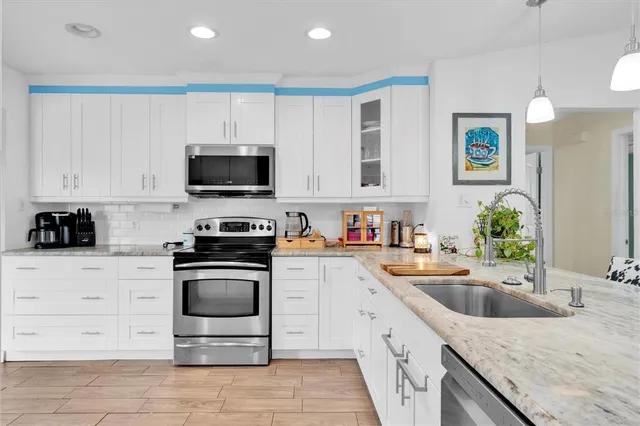 a kitchen with granite countertop a sink and a stove top oven
