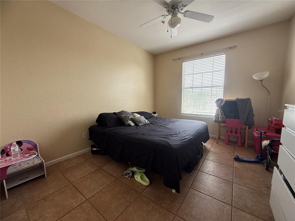 13572 Turtle Marsh Loop, Unit 230 Orlando, FL 32837 - Photo 11 of 14 a bed room with a bed and a chair