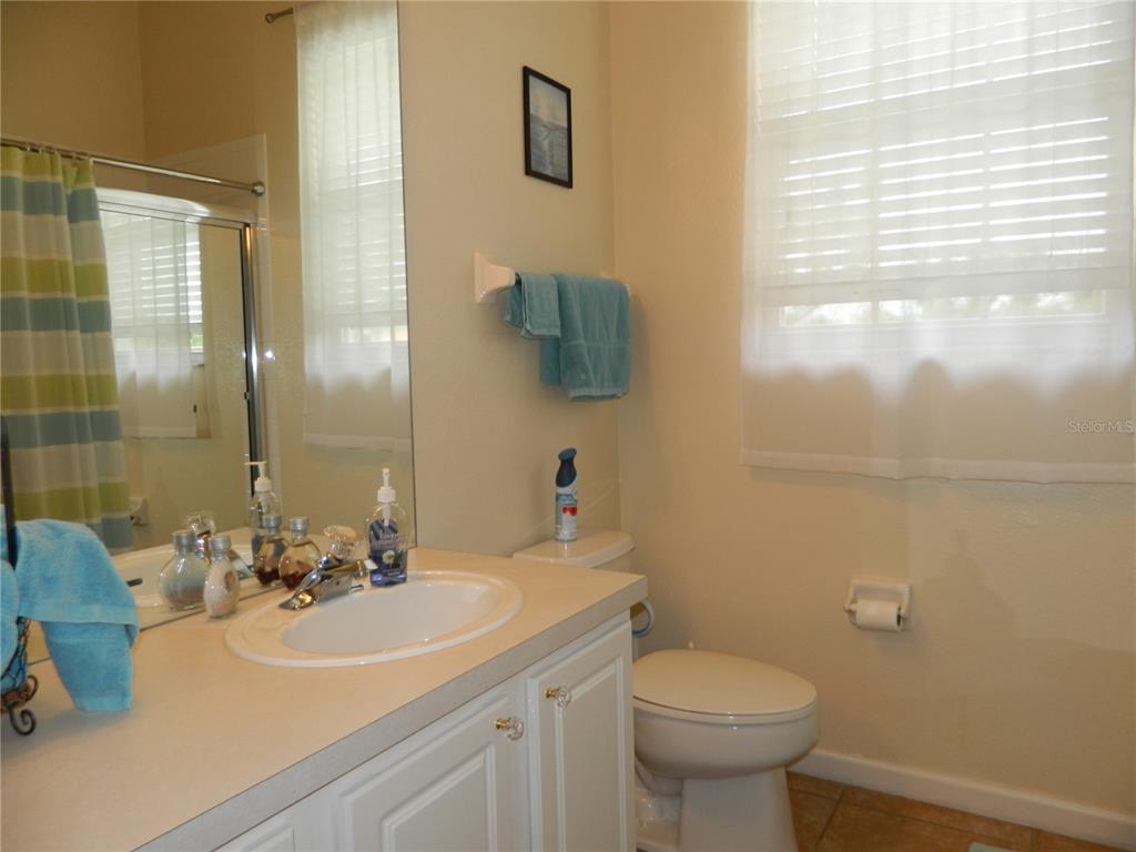 13572 Turtle Marsh Loop, Unit 230 Orlando, FL 32837 - Photo 13 of 14 a bathroom with a sink and mirror with toilet