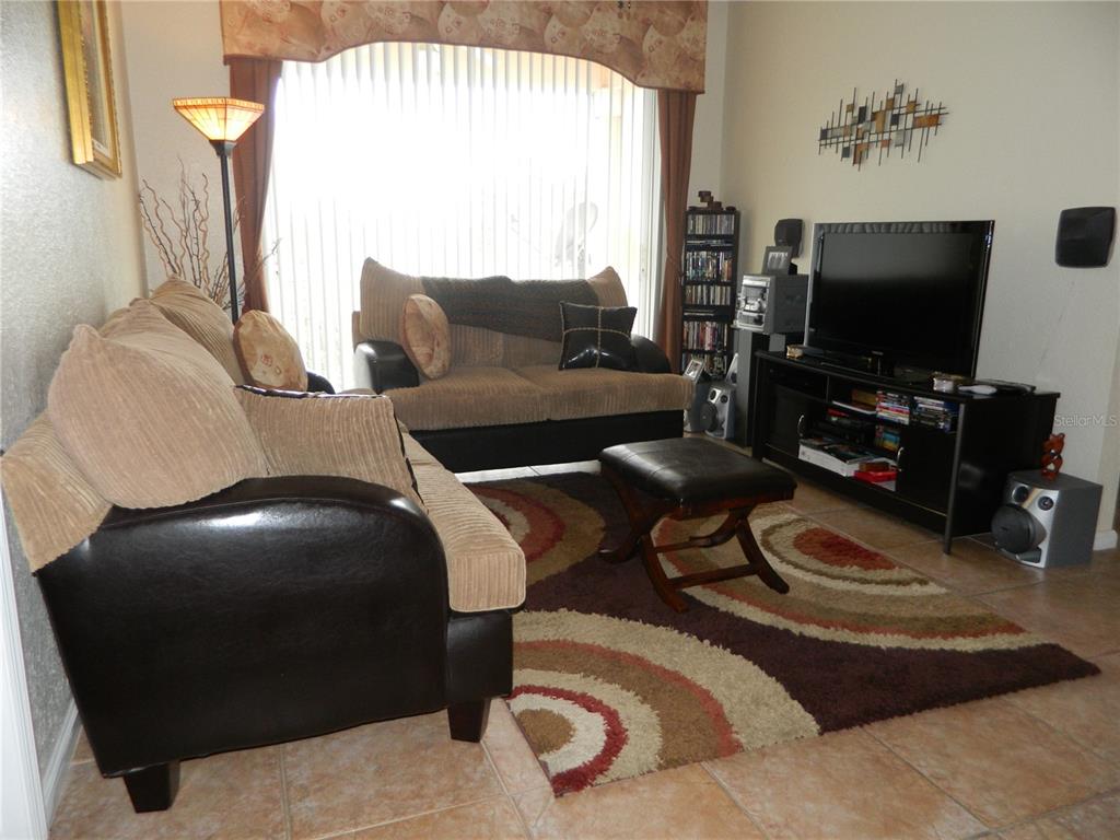 13572 Turtle Marsh Loop, Unit 230 Orlando, FL 32837 - Photo 8 of 14 a living room with furniture and a flat screen tv