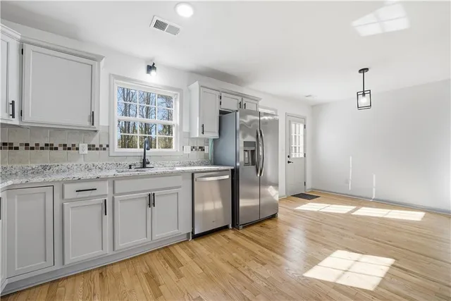 a kitchen with stainless steel appliances granite countertop a refrigerator and a sink