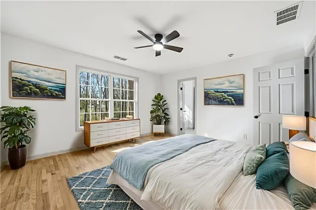 a bedroom with a large bed couch and windows