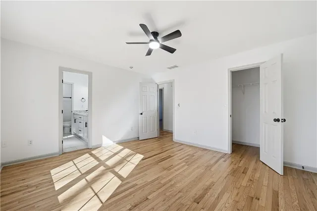 a view of a livingroom with wooden floor and a ceiling fan