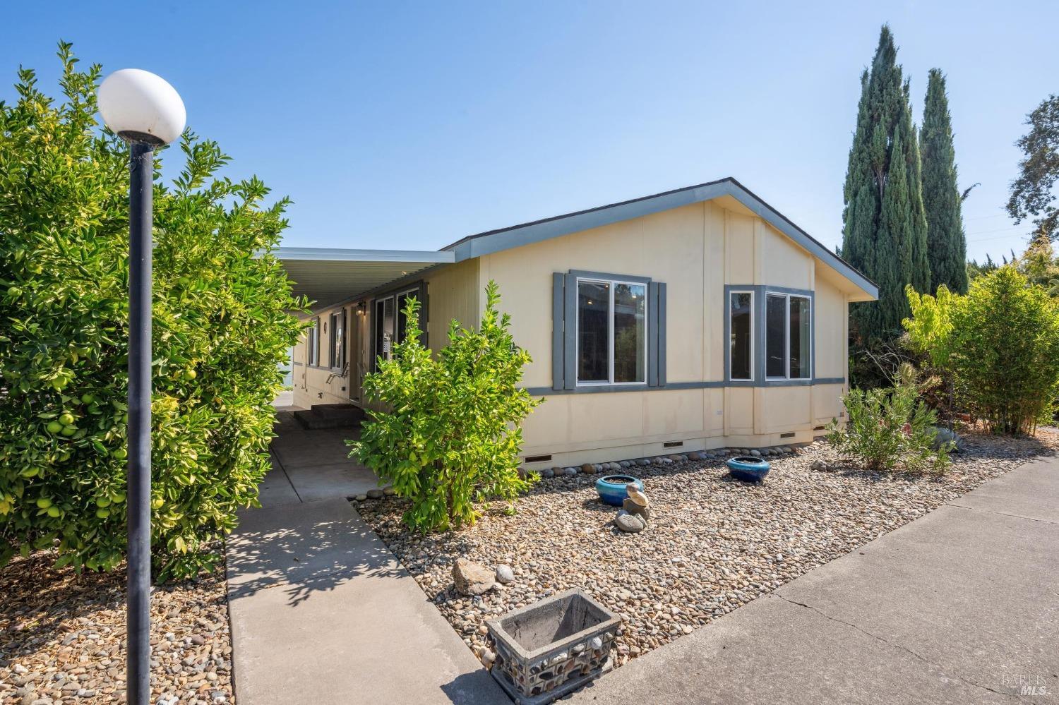 a view of a house with a yard and potted plants
