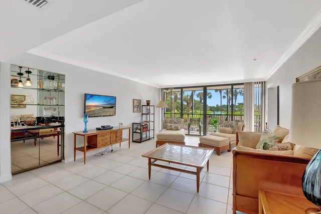 a living room with furniture a flat screen tv and a floor to ceiling window