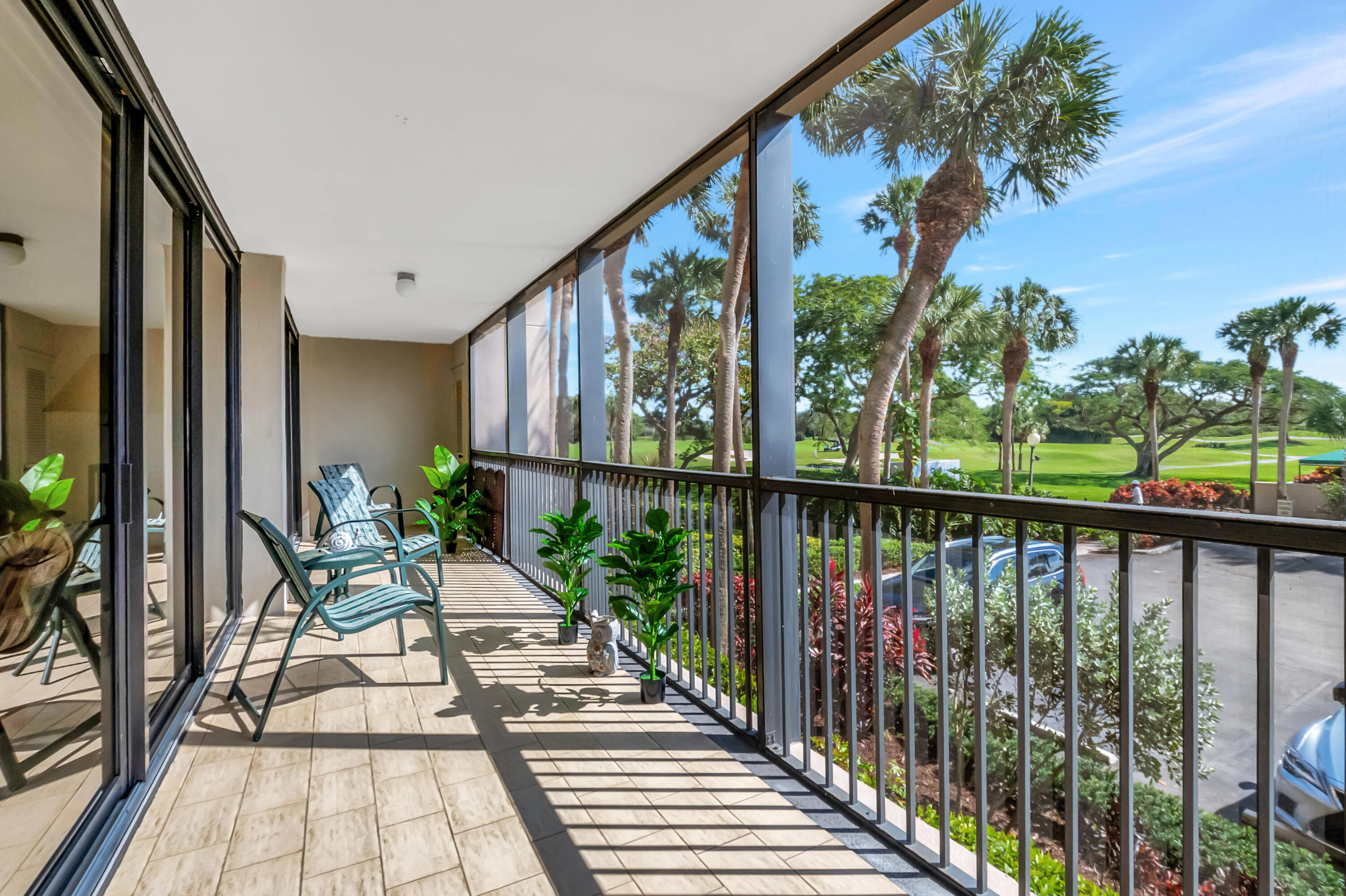 20100 Boca W Drive, Unit 126 Boca Raton, FL 33434 - Photo 25 of 58 a balcony with wooden floor and outdoor seating