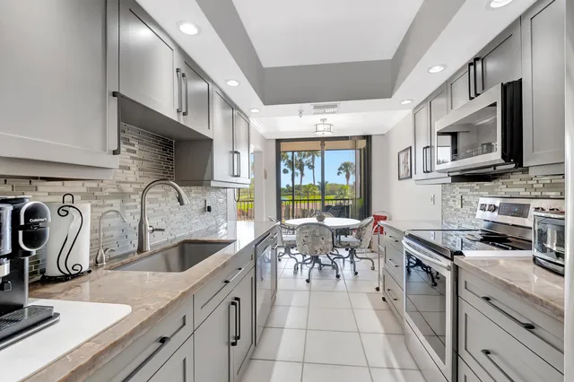 a kitchen with stainless steel appliances granite countertop a sink and a stove