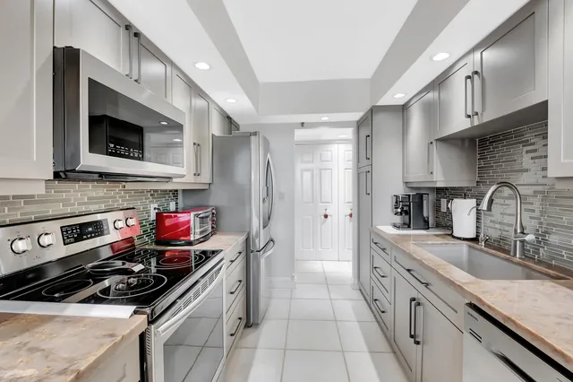 a kitchen with stainless steel appliances a stove sink microwave and cabinets