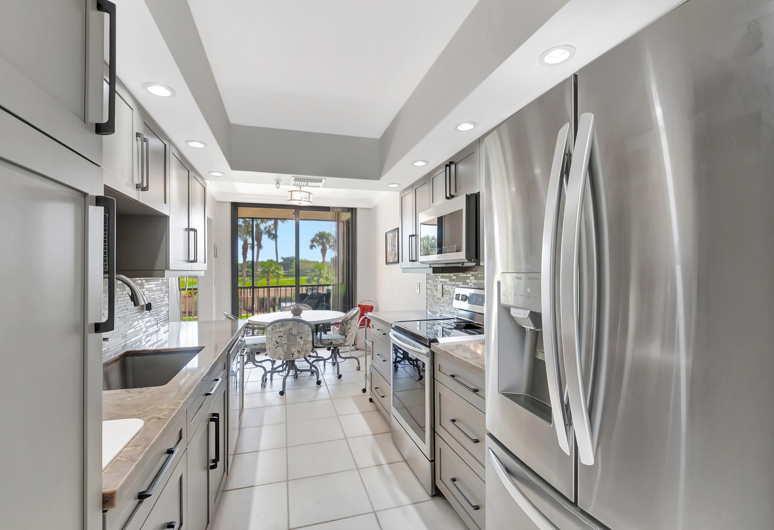 20100 Boca W Drive, Unit 126 Boca Raton, FL 33434 - Photo 10 of 58 a kitchen with stainless steel appliances granite countertop a refrigerator and a sink