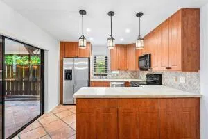 a kitchen with stainless steel appliances granite countertop wooden cabinets a sink a stove and a refrigerator