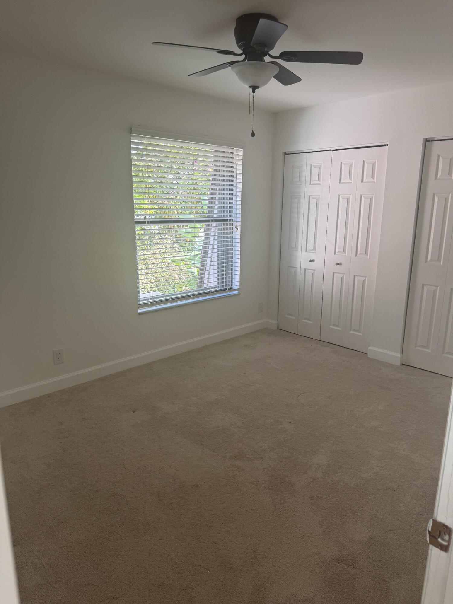 7526 Courtyard Run East Boca Raton, FL 33433 - Photo 15 of 16 an empty room with windows and fan
