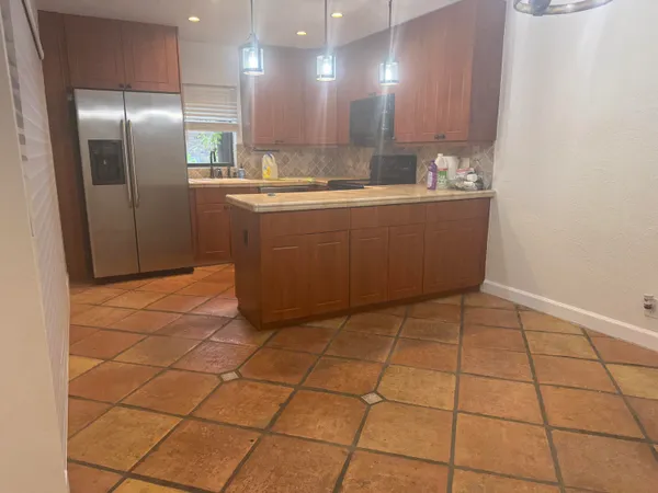 a kitchen with stainless steel appliances a sink a refrigerator and a mirror