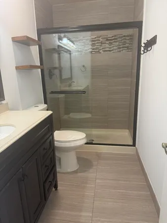 a bathroom with a shower a toilet and a sink