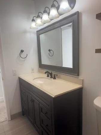 a bathroom with a toilet sink and mirror