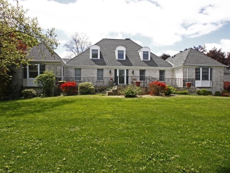 a front view of a house with a garden and trees