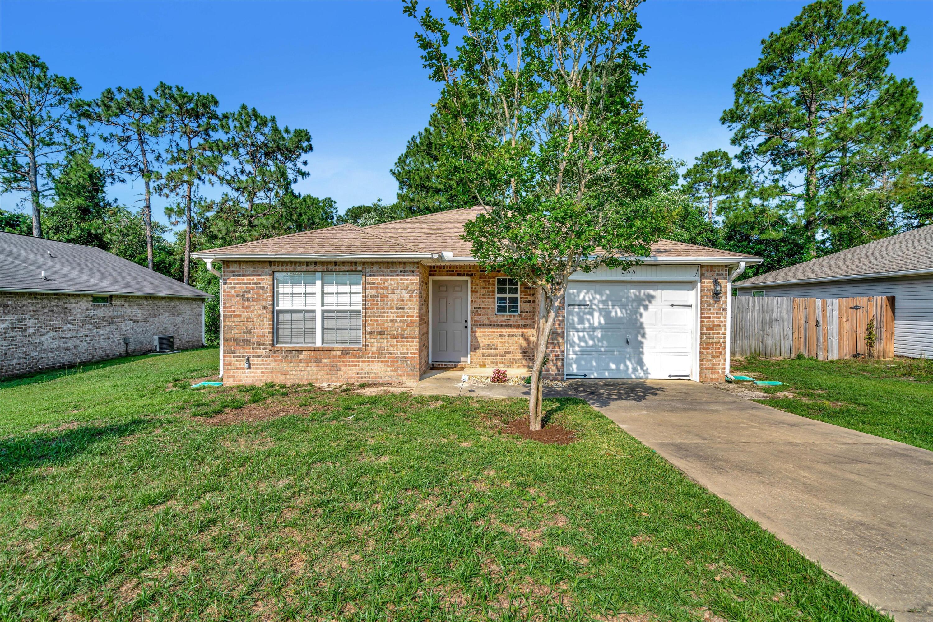 266 Limestone Circle Crestview, FL 32539 - Photo 2 of 25 a backyard of a house with a garden and large tree