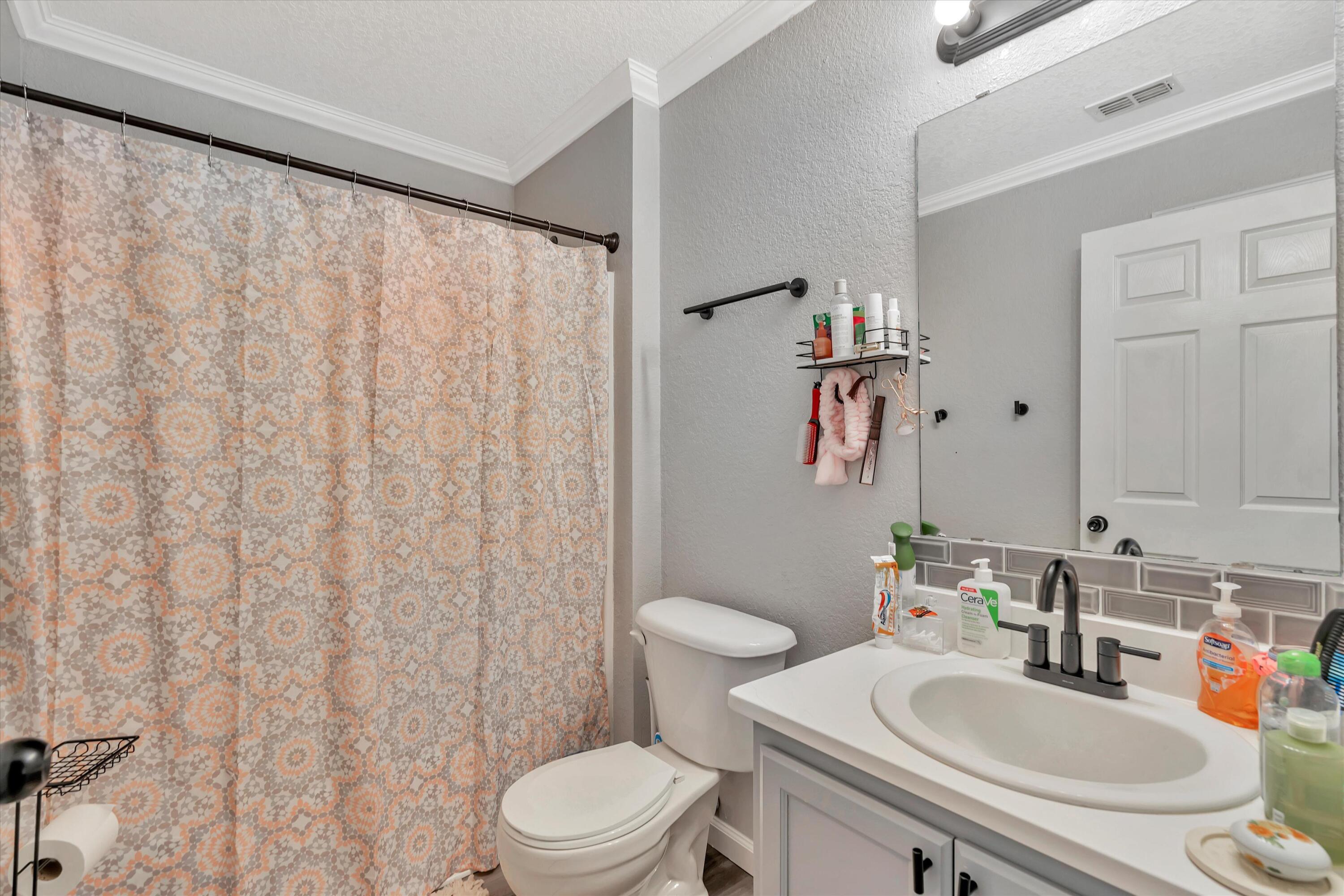 266 Limestone Circle Crestview, FL 32539 - Photo 21 of 25 a bathroom with a sink a toilet and shower curtain