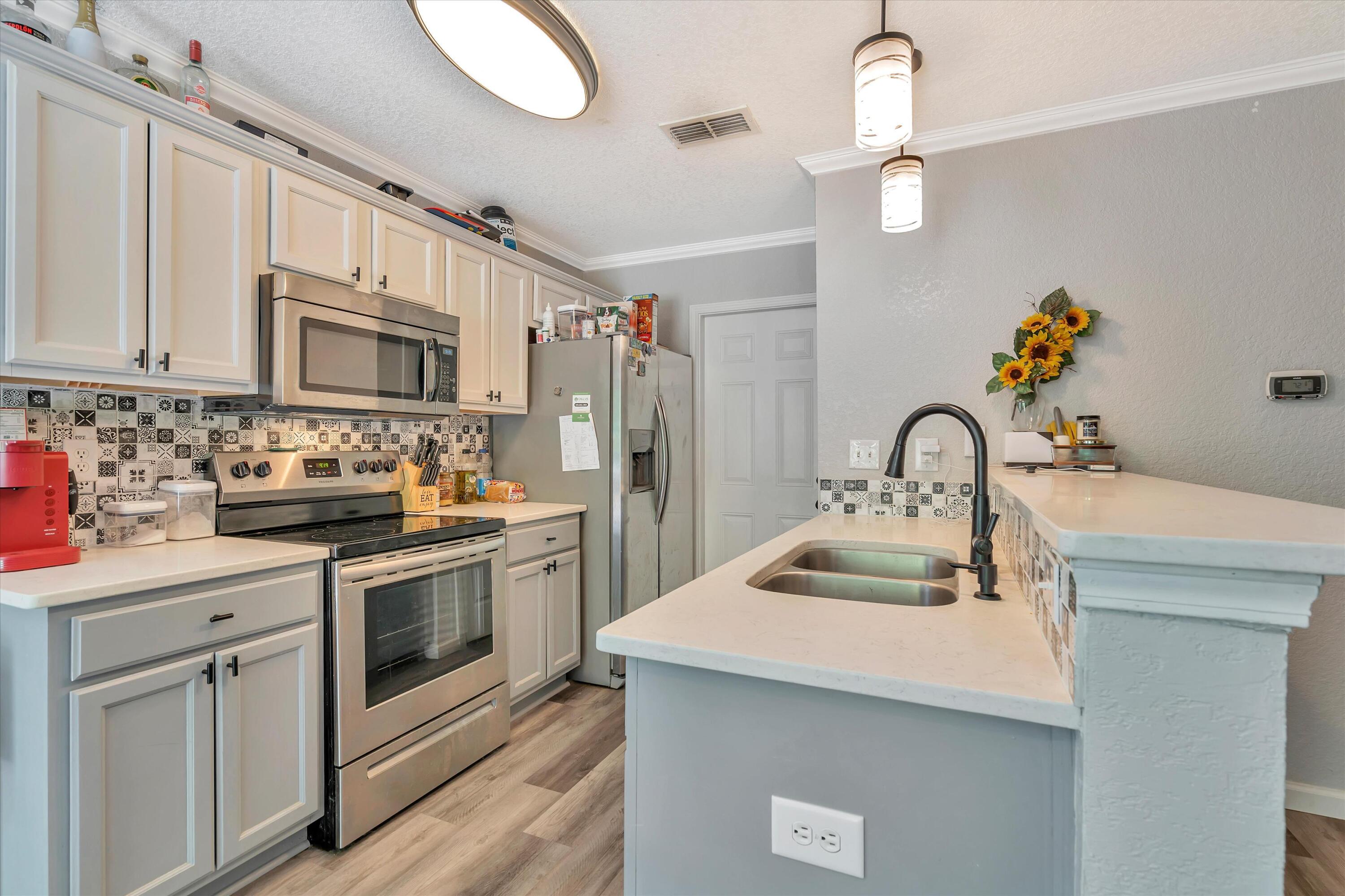 266 Limestone Circle Crestview, FL 32539 - Photo 8 of 25 a kitchen with stainless steel appliances granite countertop a sink stove and refrigerator