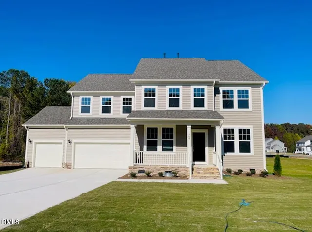 a front view of a house with a garden and yard