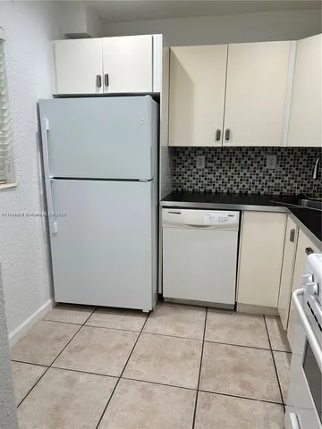 a white refrigerator freezer sitting inside of a kitchen