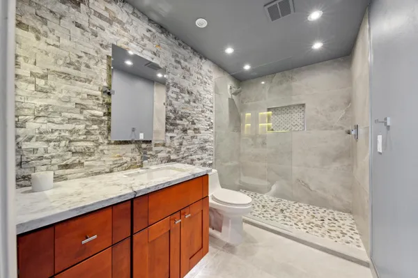 a bathroom with a double vanity sink toilet and shower