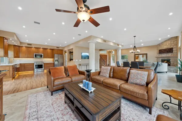 a living room with furniture kitchen view and a chandelier