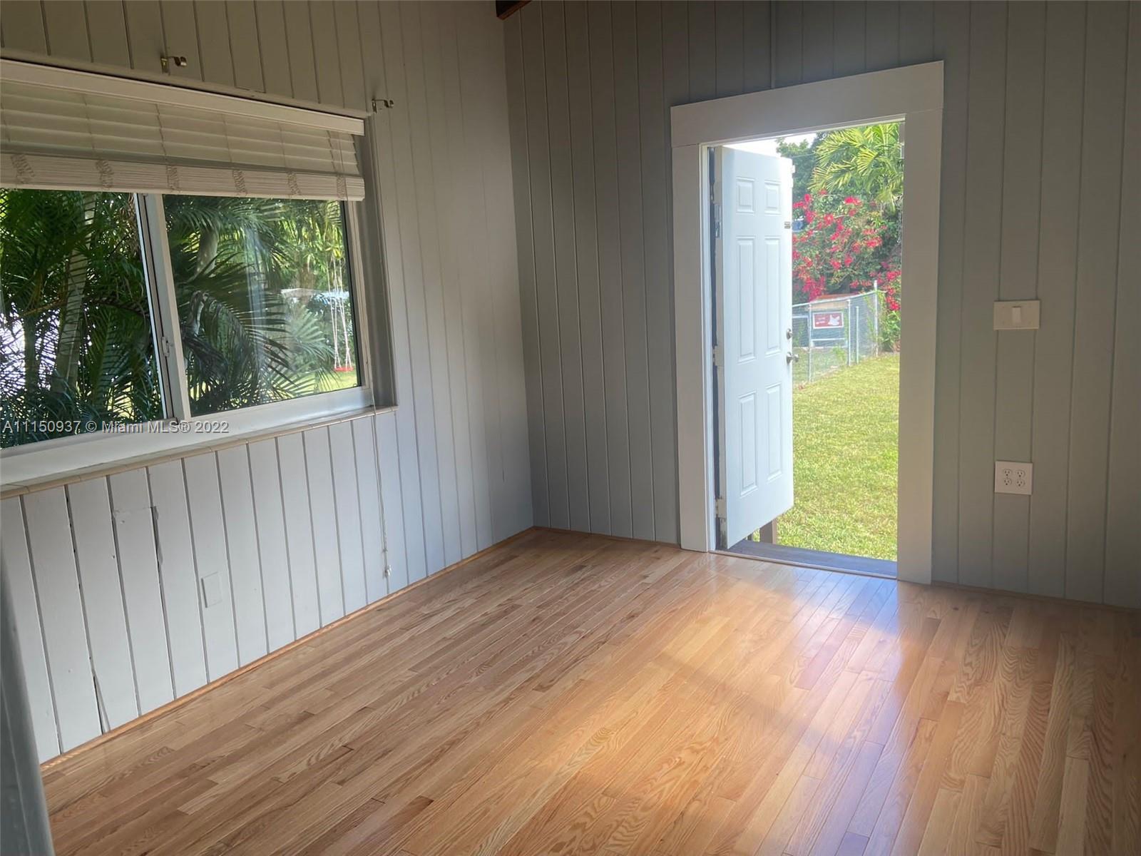 155 Southwest 28th Road Miami, FL 33129 - Photo 14 of 33 a view of an empty room with wooden floor and a window