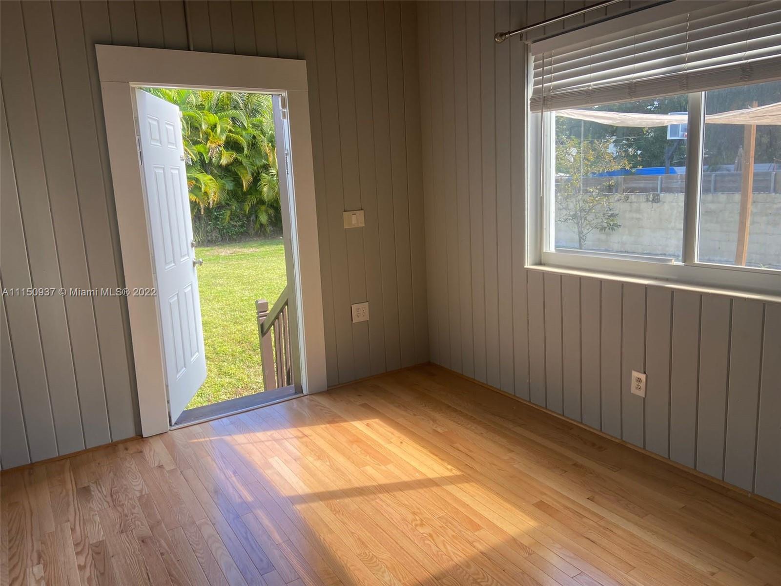 155 Southwest 28th Road Miami, FL 33129 - Photo 15 of 33 a view of an empty room with a window and wooden floor