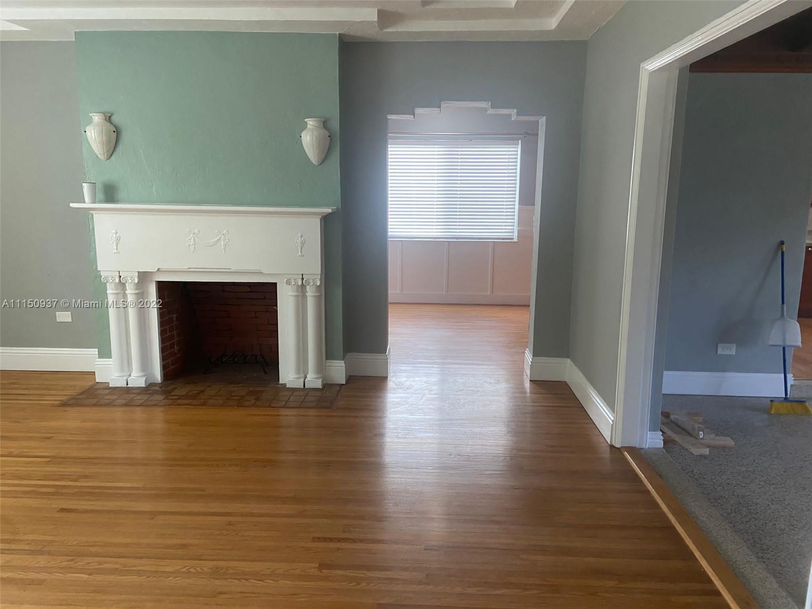 155 Southwest 28th Road Miami, FL 33129 - Photo 3 of 33 a view of an empty room with wooden floor and a fireplace
