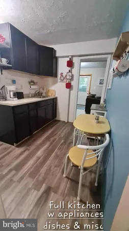 a kitchen with a stove a refrigerator and wooden floor