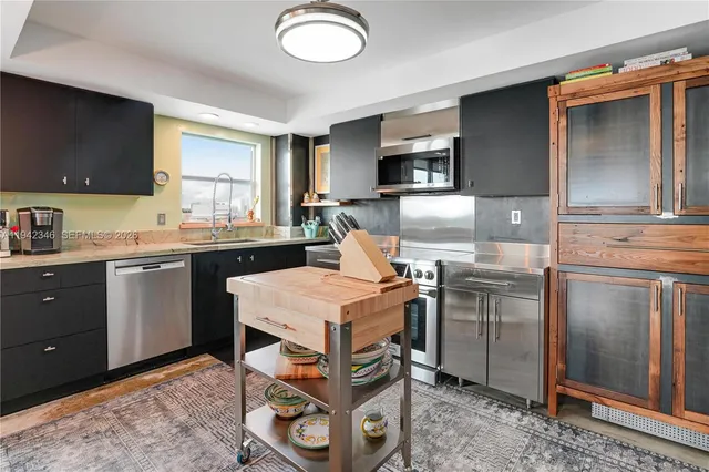a kitchen that has a sink a stove and chairs