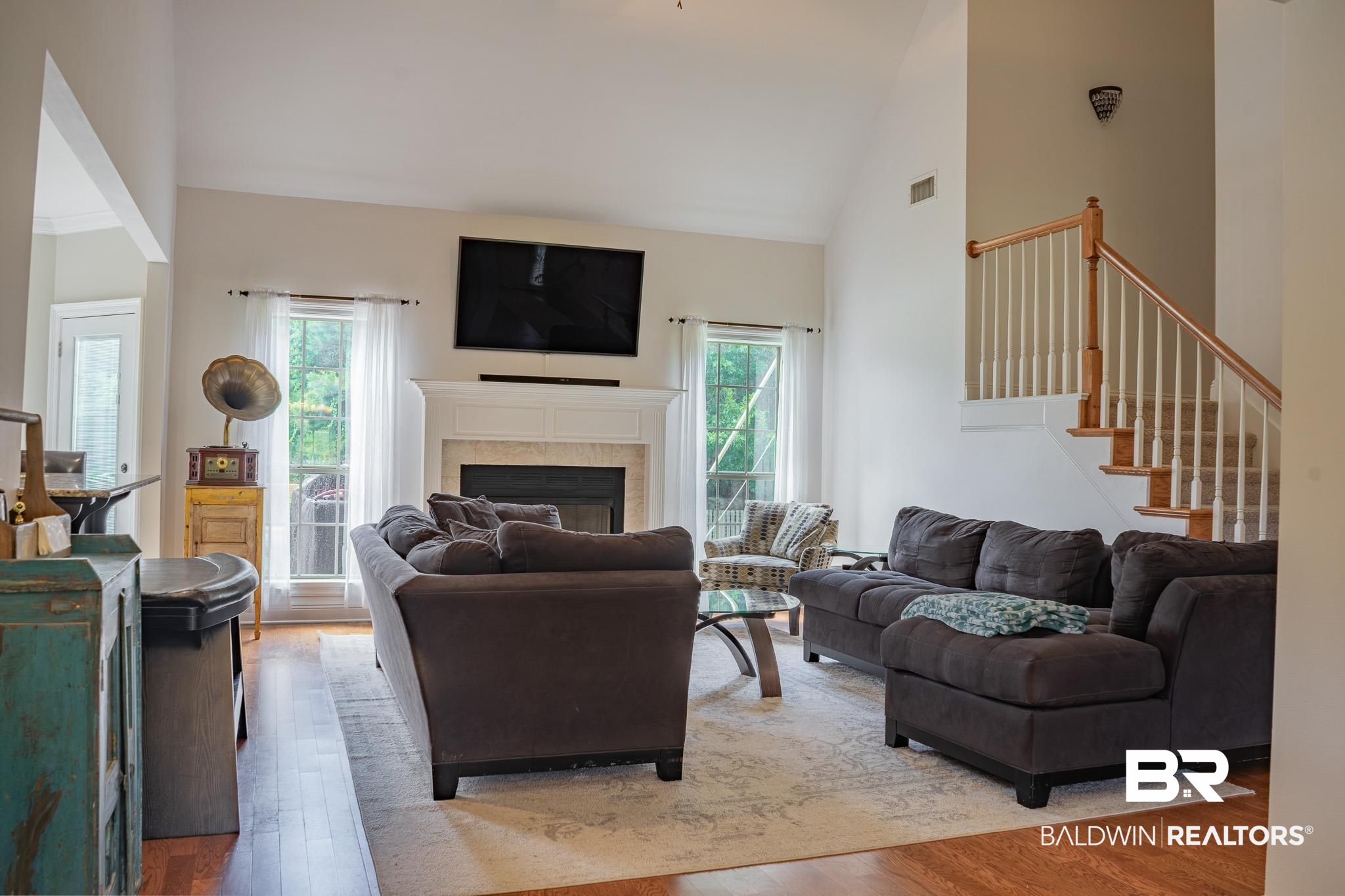 8421 Weatherford Court Daphne, AL 36527 - Photo 7 of 36 Living room featuring healthy amount of natural light, light wood finished floors, a fireplace, high vaulted ceiling, and stairs
