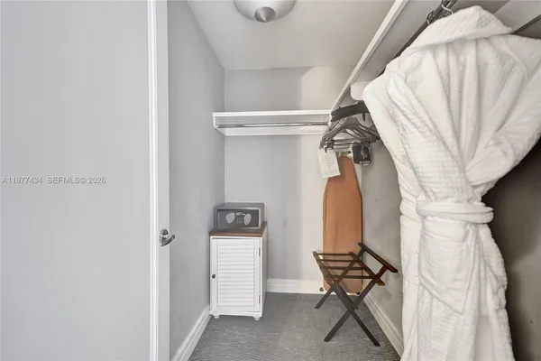 a view of walk in closet with clothes and shoes