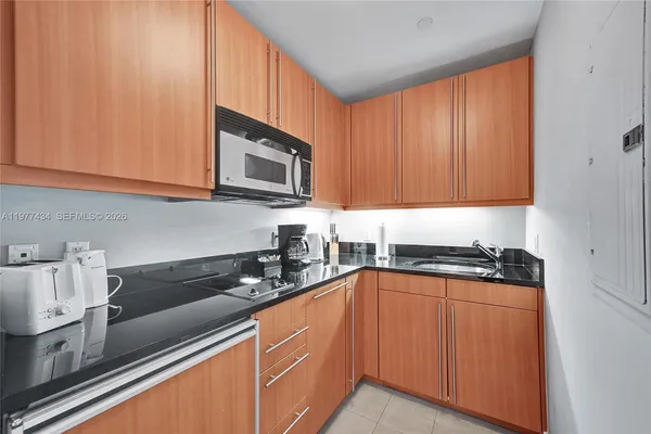 a kitchen with a refrigerator and a stove top oven