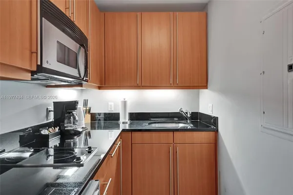 a kitchen with stainless steel appliances a sink stove top oven and cabinets