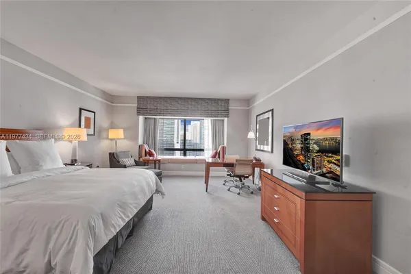a bedroom with furniture and a flat screen tv