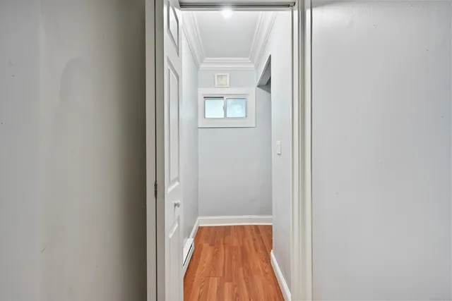 a view of a hallway with wooden floor and a window