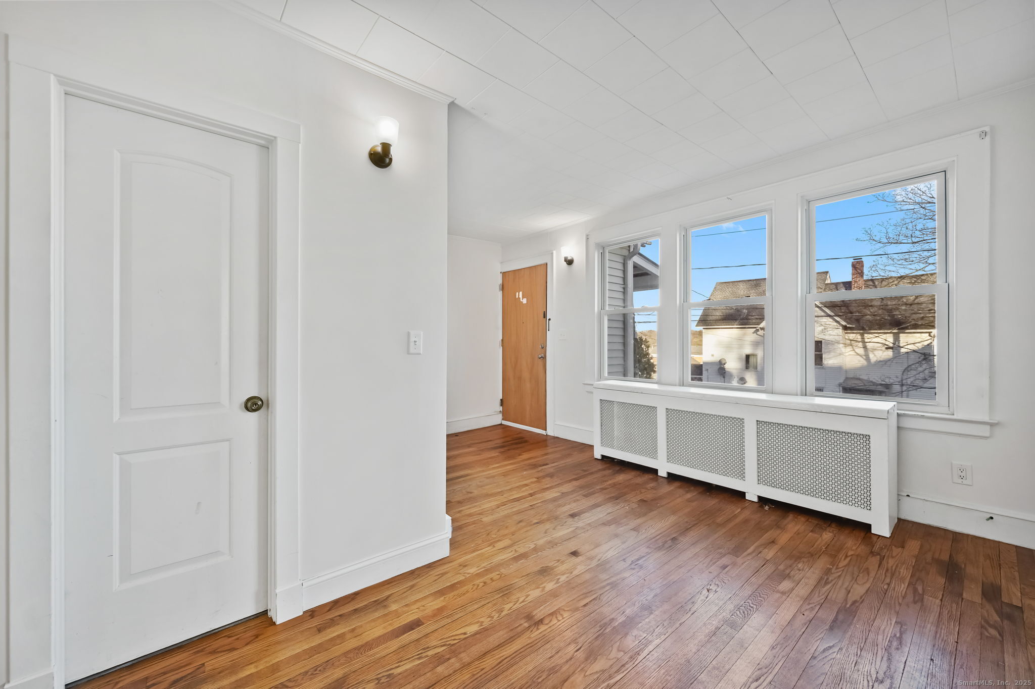 8 Smith Street, Unit 1 Danbury, CT 06810 - Photo 3 of 23 a view of an empty room with window and wooden floor