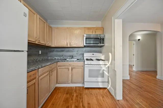 a kitchen with stainless steel appliances granite countertop a stove a sink and a microwave