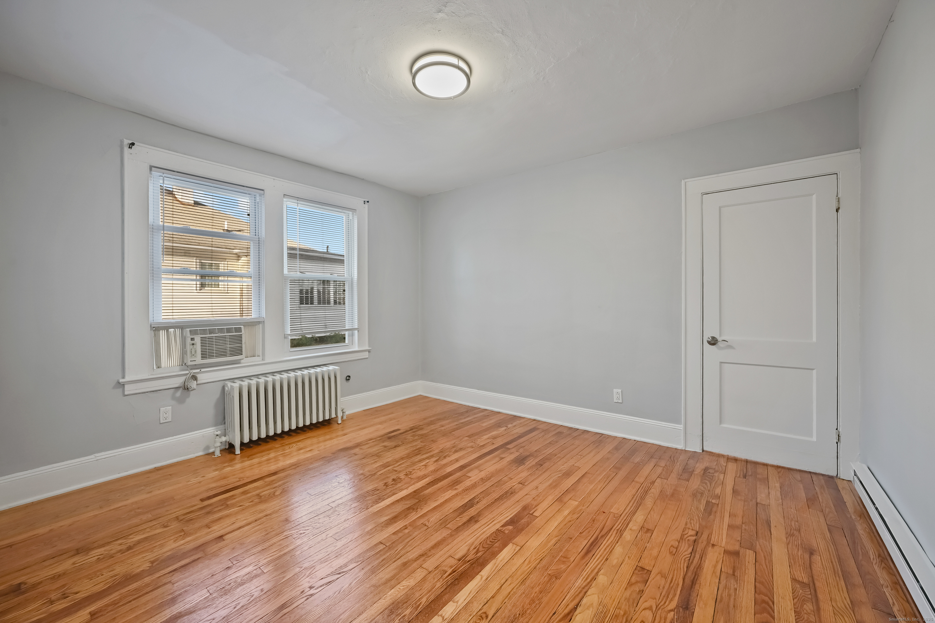 8 Smith Street, Unit 1 Danbury, CT 06810 - Photo 9 of 23 wooden floor in an empty room with a window