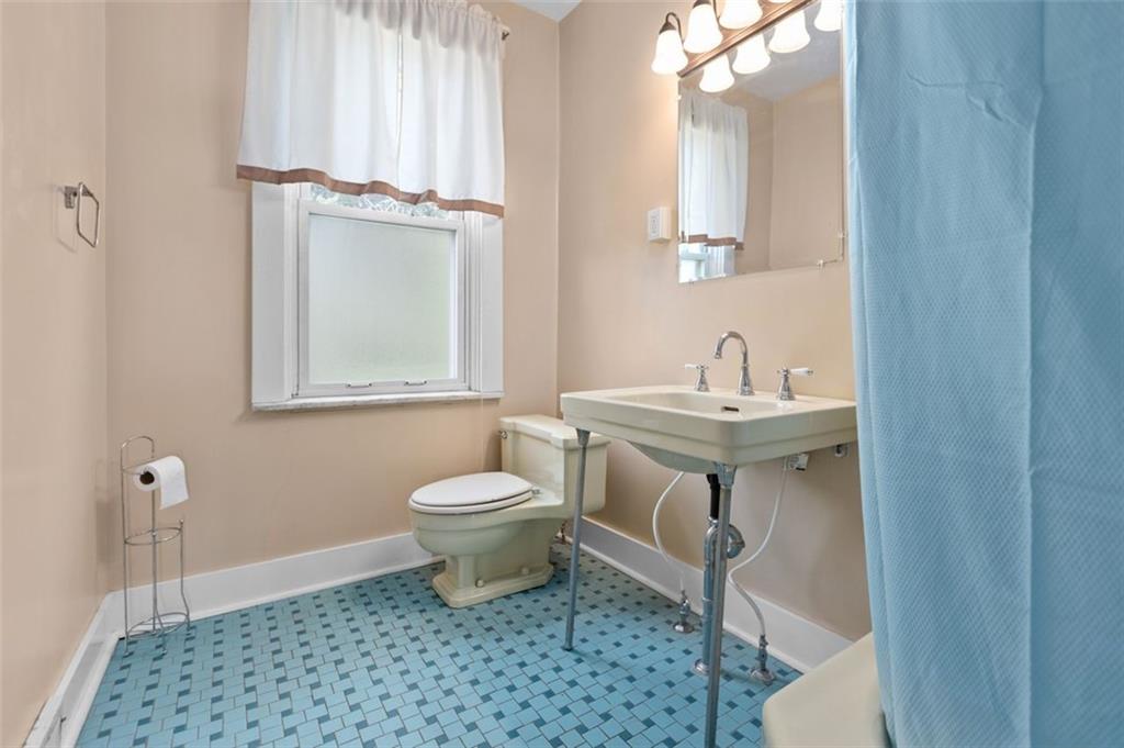 11 Butler Street Pittsburgh, PA 15209 - Photo 23 of 29 a bathroom with a sink a toilet and mirror