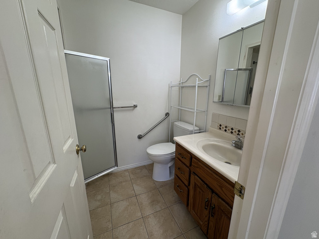 486 West 120 North Orem, UT 84057 - Photo 13 of 30 Bathroom featuring a glass-enclosed shower, a wood-finish vanity with an integrated sink, tile flooring, and a mirrored medicine cabinet