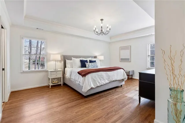 a bedroom with a bed chandelier and a window