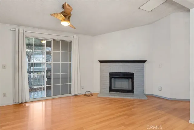 a view of an empty room with a fireplace and a window