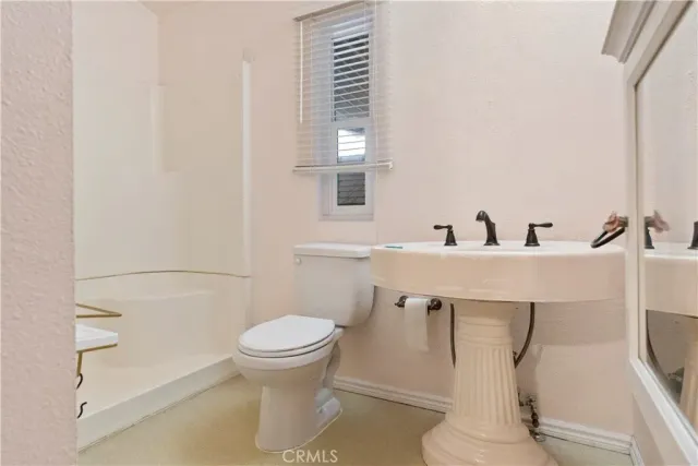 a bathroom with a toilet a sink and mirror