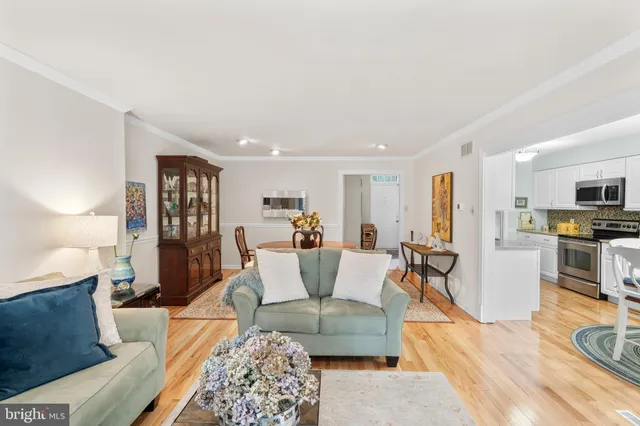 a living room with furniture a dining table and chairs with wooden floor