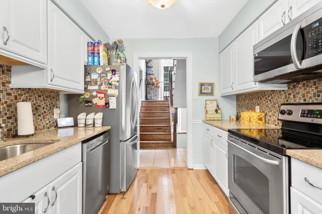 a kitchen with stainless steel appliances granite countertop a refrigerator and a stove top oven