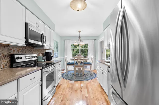 a kitchen with stainless steel appliances a stove a sink and a refrigerator