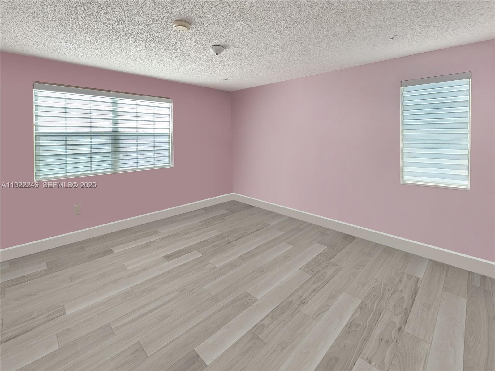 12759 Southwest 146th Terrace Miami, FL 33186 - Photo 3 of 10 an empty room with wooden floor and windows