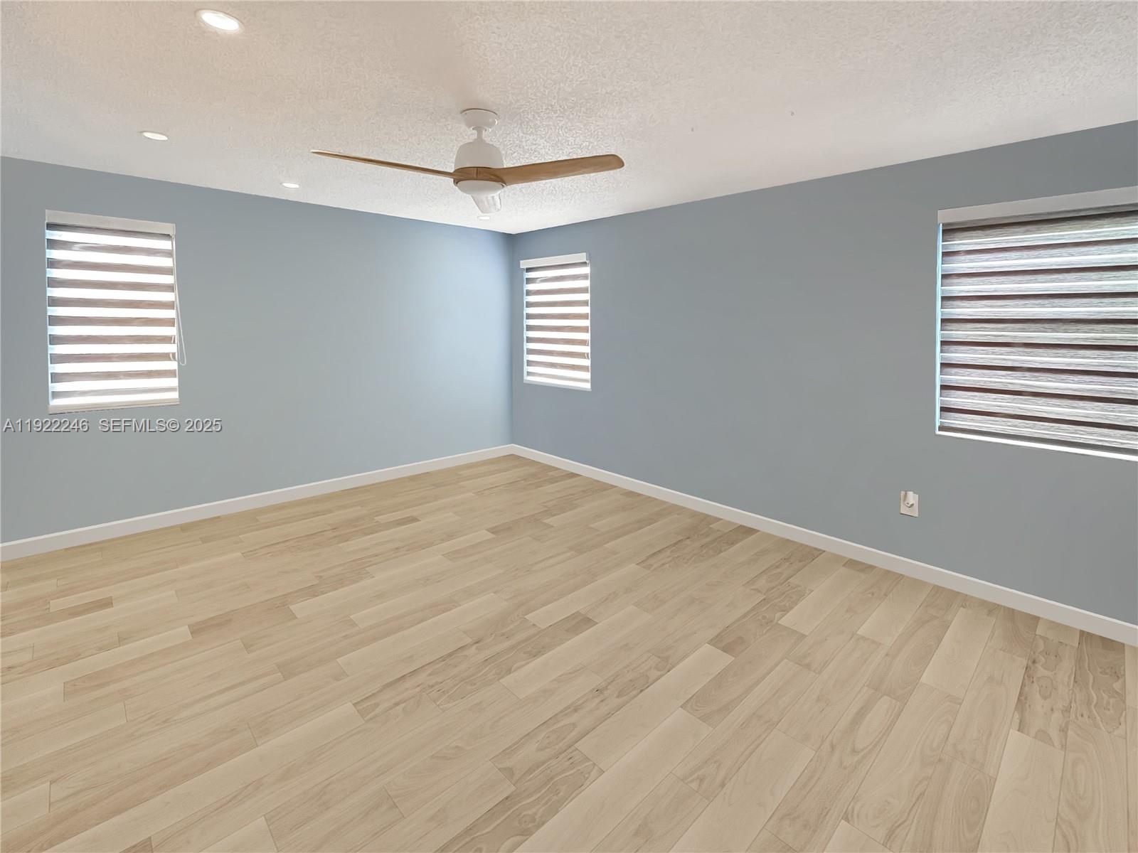 12759 Southwest 146th Terrace Miami, FL 33186 - Photo 4 of 10 an empty room with windows and fan
